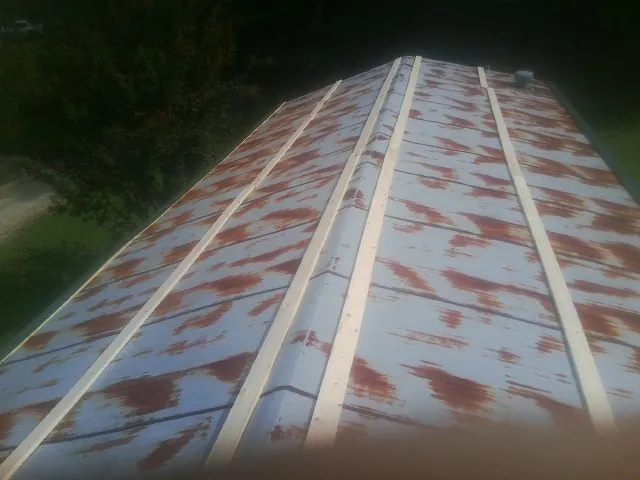 Rusted metal roof panels with new wood purlins before replacement — Storm Damage Roof Repair in West Springfield by Roofing Brothers